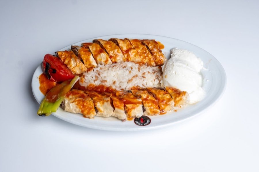 Beyti doner with tomato sauce, rice, yogurt and grilled vegetables on a Doner Point plate