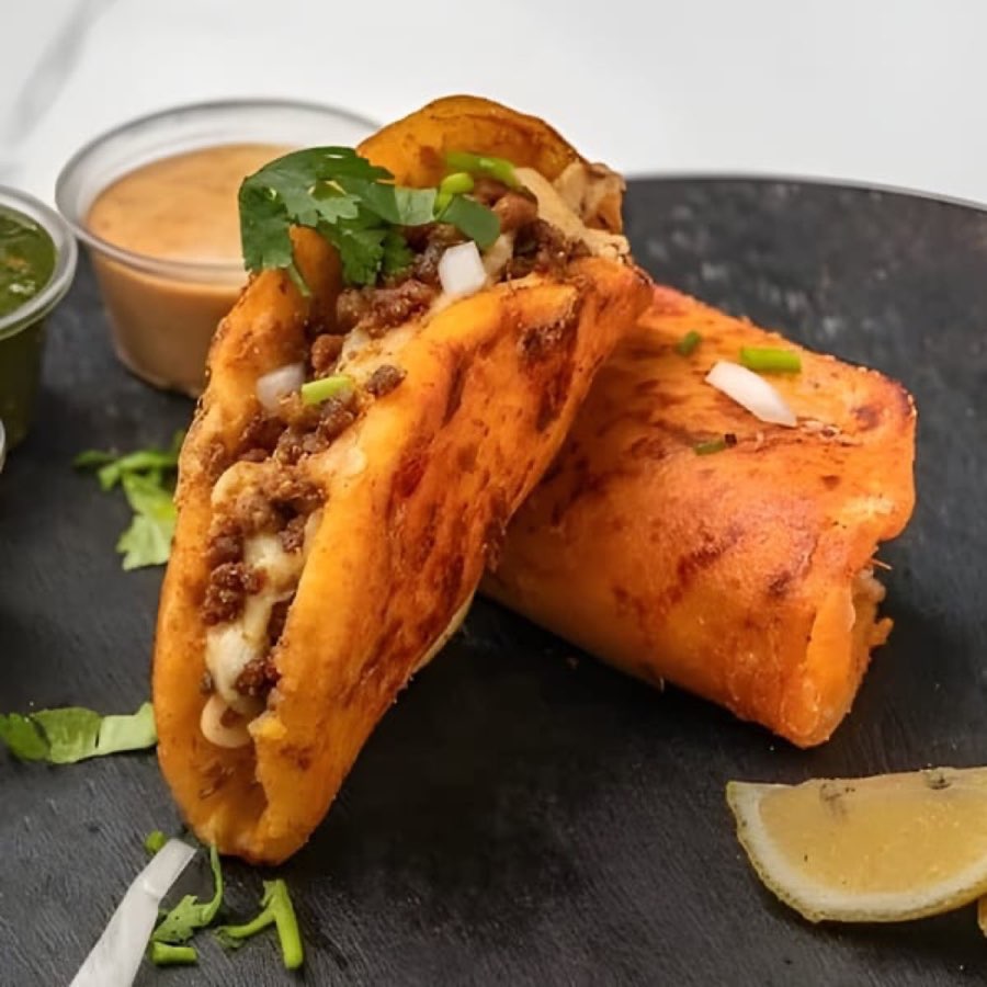 Halal Fusionz birria tacos with herbs and dipping sauce.