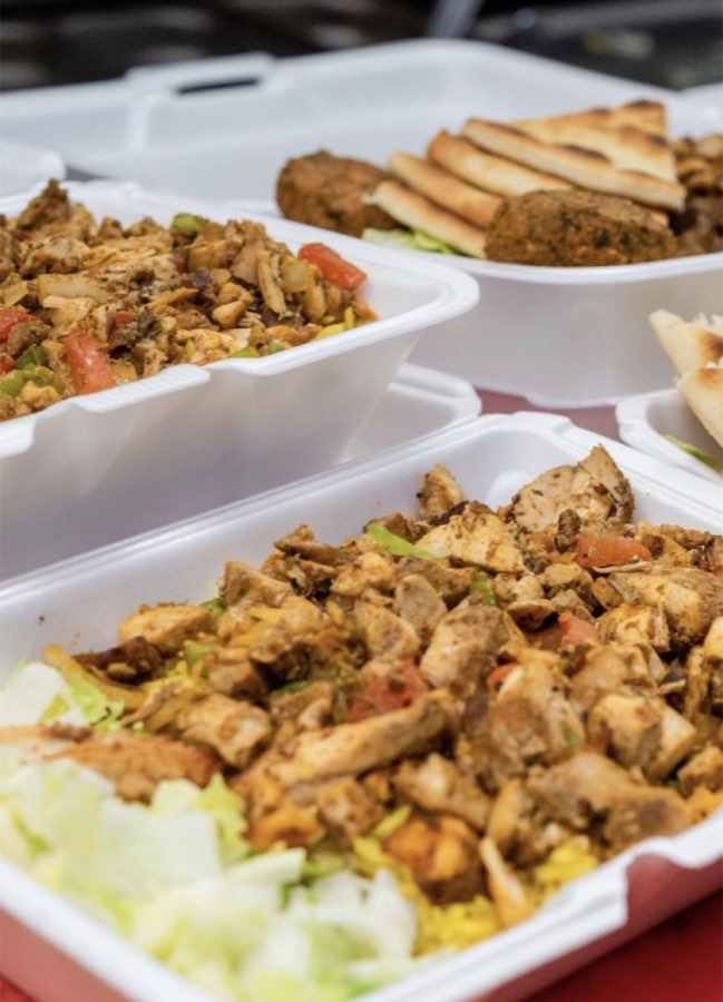 Takeout trays of seasoned chicken, rice, salad, pita and falafel
