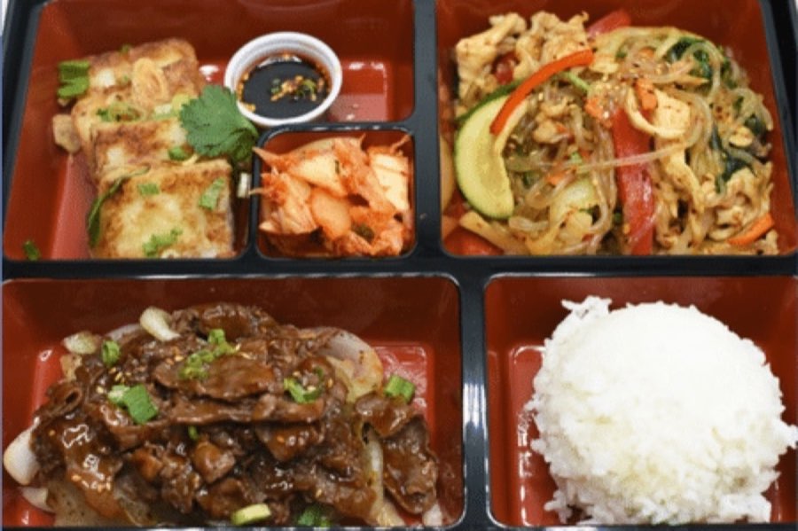 Bento tray with rice, noodles, meat, dumplings and kimchi