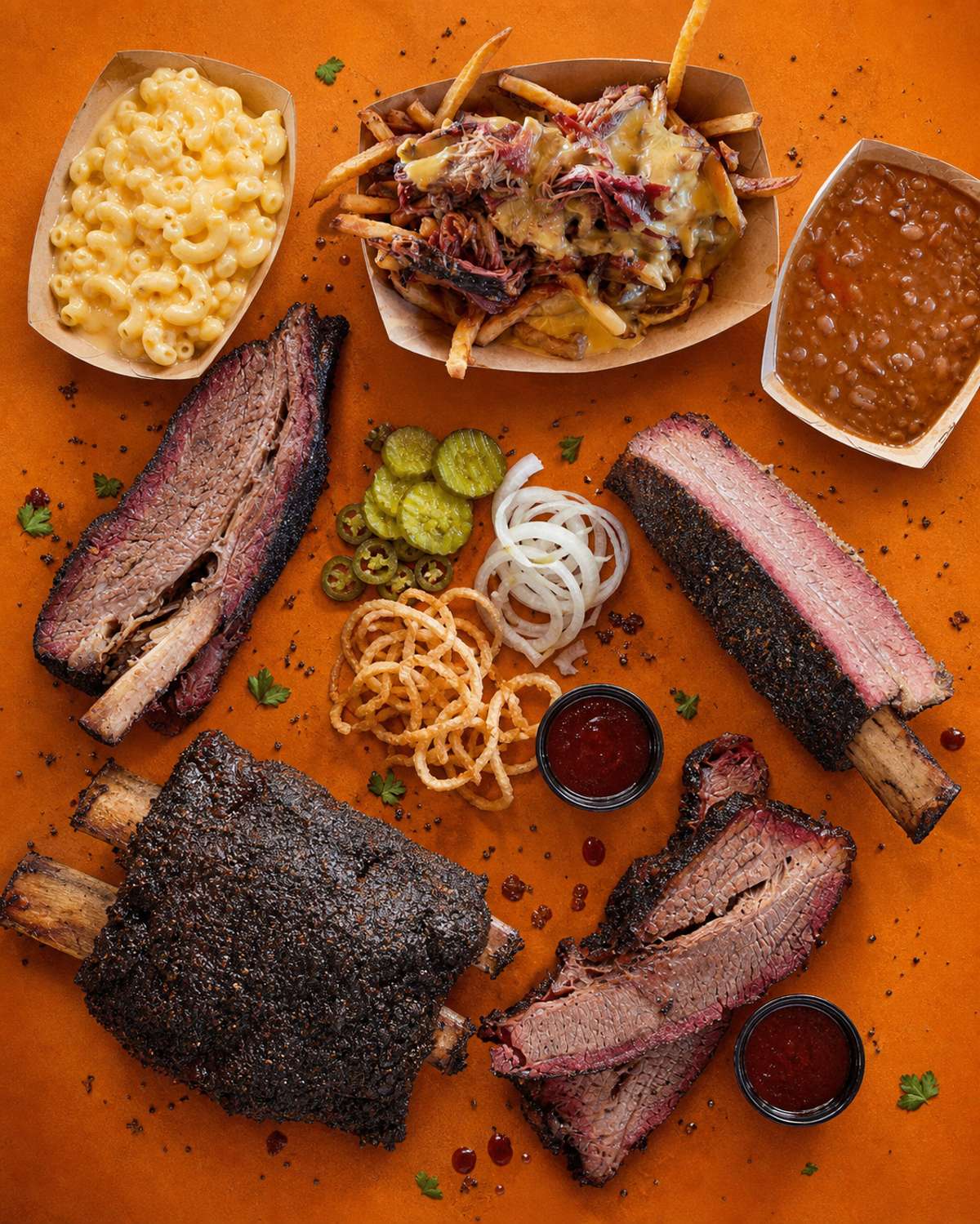 Smoked beef ribs and brisket with loaded fries, macaroni and cheese, beans and pickles